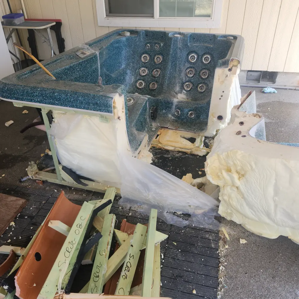 Old fiberglass hot tub being dismantled for removal on a backyard patio in Keizer, OR